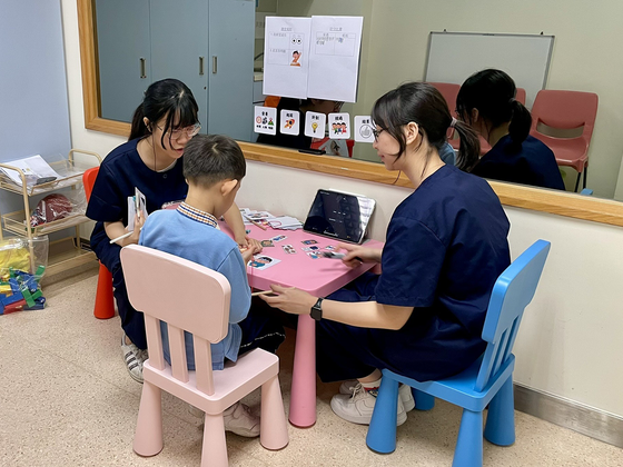 Students playing card game with a child