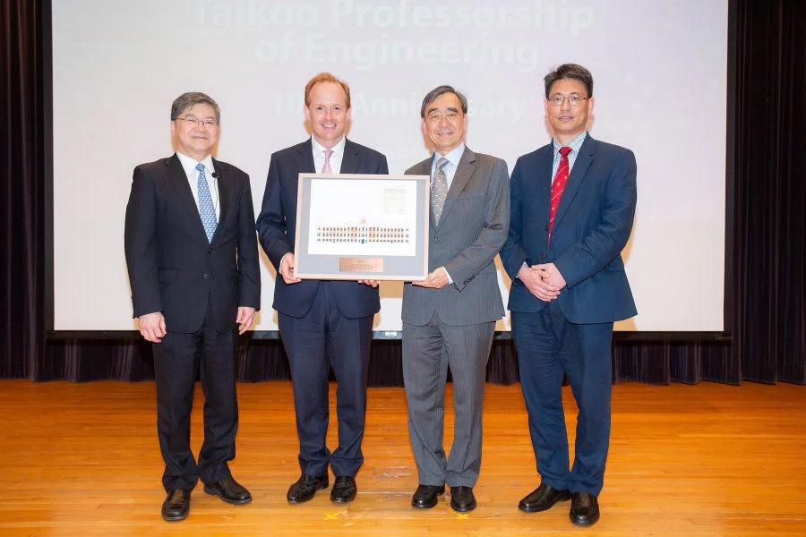 Souvenir presentation: (left to right) Norman Tien, Taikoo Professor of Engineering; Mr Merlin Swire, Chairman of John Swire & Sons (H.K.) Limited; Professor Richard Wong Yue-Chim, Provost & Deputy Vice-Chancellor of HKU; Professor Christopher Chao Yu-Hang, Dean of Engineering, HKU. The souvenir is a 2019 illustration of the Main Building which was completed in 1911.