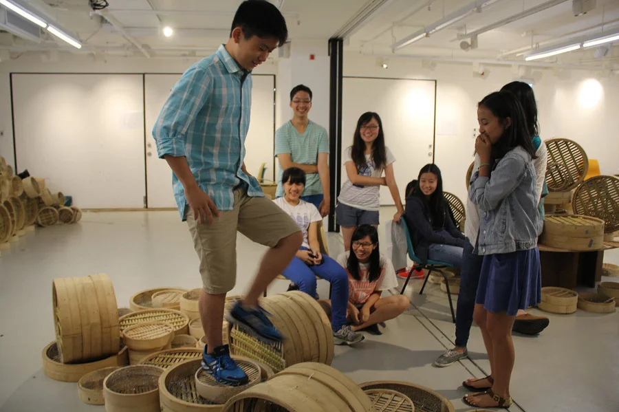Students testing the structural stability of their bamboo steamer structure