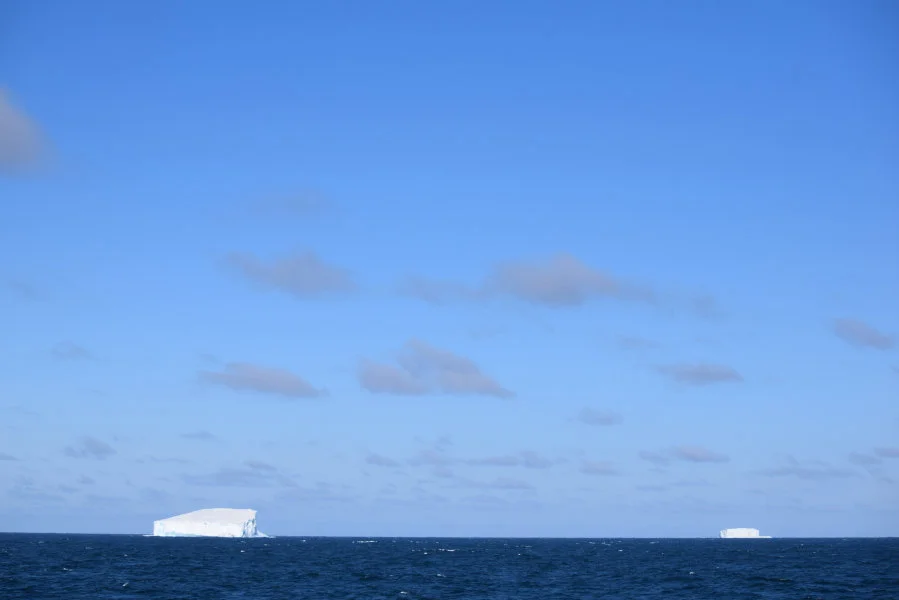 Beneath the vast blue sky, the icebergs of the Southern Ocean stand silently, witnessing one of Earth's most untouched and fragile beauties. Photo credit: Minoru Ikehara.  