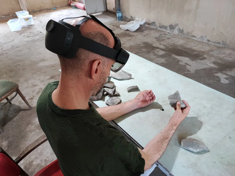 HKU Faculty of Arts Professor Peter J. Cobb compares the 3D model of a virtual pottery sherd with an adjoining real sherd. (Photo credit: HKU Faculty of Arts)   