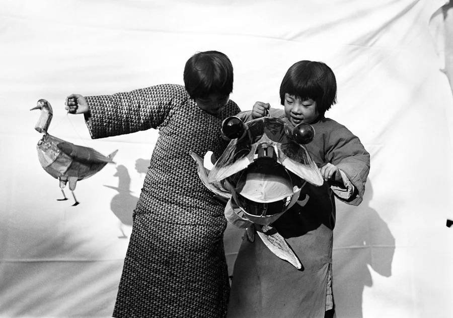Children with a paper toy and kite from a carnival.