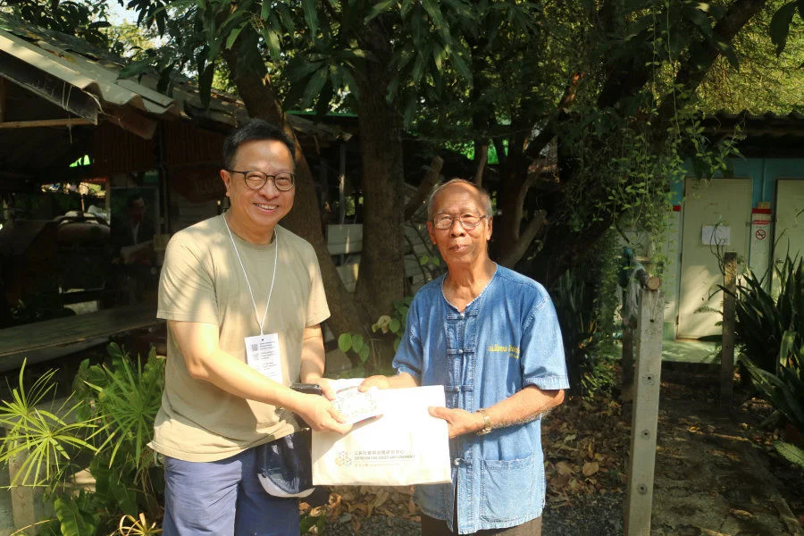 Mr. Boonlom Taokaew of Suan Lom Sirin, the Community Sufficiency Agriculture Learning Centre in Thailand, receives a souvenir from Professor Wai-Fung Lam of The University of Hong Kong