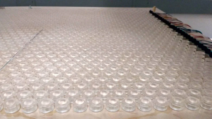 Experimental setup: the artificial phononic crystals are designed and fabricated by the research team. Sound emitted from the loudspeakers array normally propagates from the right and excites the relativistic quasiparticle inside the phononic crystals. A mini microphone is attached to a 3D motion motor to scan the pressure field  